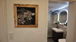 a bathroom with a painting of a cow on the wall at Ferienwohnungen Boxler in Oberstdorf