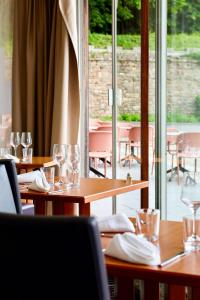 a restaurant with wooden tables and chairs with wine glasses at Logis Hôtel Du Château - Combourg, Proche Saint-Malo in Combourg +54 photos