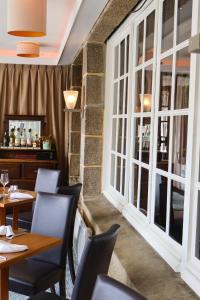 a restaurant with tables and chairs and large windows at Logis Hôtel Du Château - Combourg, Proche Saint-Malo in Combourg