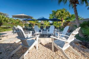 a group of white chairs and tables with umbrellas at Poolside Palms - Team Joseph Ellen in Jacksonville Beach