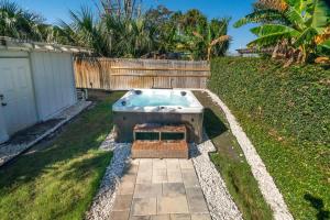 a backyard with a hot tub in the grass at Poolside Palms - Team Joseph Ellen in Jacksonville Beach