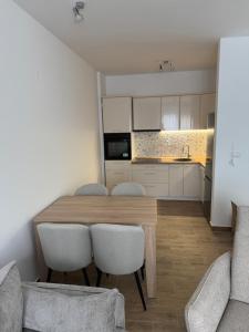 a kitchen and dining room with a wooden table and chairs at Apartman 38 in Stara Pazova