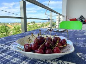 a bowl of cherries sitting on a table at Sunrise Apartment Qerret in Kavajë