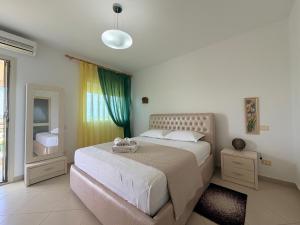 a bedroom with a large bed and a window at Sunrise Apartment Qerret in Kavajë