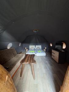 a room with a bed and a table in a tent at Czarci Zakątek in Pozezdrze