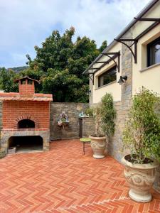 a brick patio with a brick fireplace next to a house at Dimora Pepatio in Camporosso