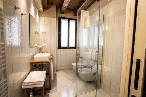 a bathroom with a shower and a toilet and a sink at Casa Delneri Boutique Hotel Adults Only in Aquiléia +21 photos