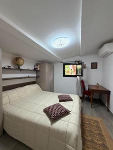 a bedroom with a large white bed and a table at Dimora Pepatio in Camporosso