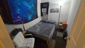 a small room with a small bed and a chair at Grateful Hemphill in Atlanta