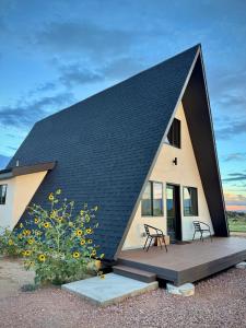 a small house with a black roof at Observer Ranch Campground & Learning Center in Penrose