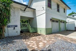 a white house with a green door and a driveway at Riberia Columbus Cottage - Team Joseph Ellen in St. Augustine