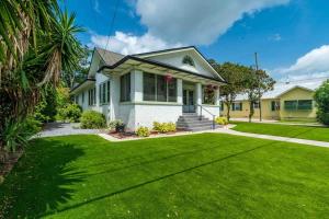 a house with a green lawn in front of it at Riberia Columbus Cottage - Team Joseph Ellen in St. Augustine