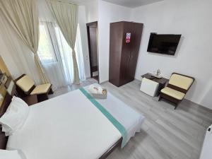 a hotel room with a bed and a tv at Casa Izabela in Năvodari