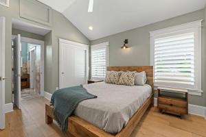 a bedroom with a large bed and windows at Riberia Columbus Cottage - Team Joseph Ellen in St. Augustine