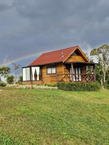 a wooden house on a hill with a green field at Cabana Davos in Timbe do Sul +16 photos