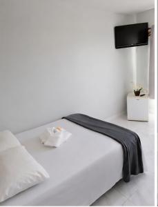 a bedroom with a white bed with a flat screen tv at Hotel Goldem Park in Brasília