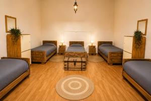a room with four beds and a table at Silvestre Hostel in Pichilemu