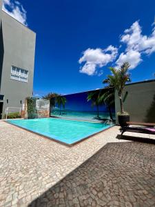 a swimming pool with a view of the ocean at Primum Palace Hotel in Dracena