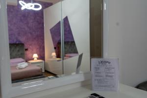 a room with a mirror with a bed and a sign at Casa Lady in Pontremoli