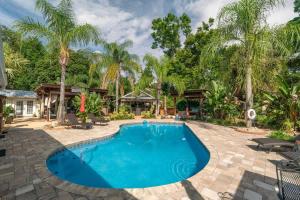 a swimming pool in a backyard with palm trees at Saint Johns Oasis - Pool Hot Tub Grill in Jacksonville