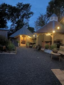 a house with a gazebo and a bench at night at Lucker mill shepherds huts in Lucker