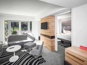 a hotel room with a bed and a living room at Novotel Resort & Spa Biarritz Anglet in Anglet
