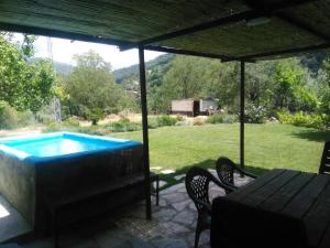 a swimming pool in a yard with a table and chairs at Comfortable lakeside house! in Güéjar-Sierra