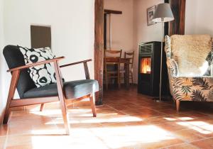 a living room with two chairs and a fireplace at Comfortable lakeside house! in Güéjar-Sierra