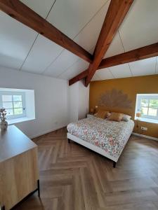 a bedroom with a bed in a room with wooden ceilings at Les Gites de la Bastide in Ribes