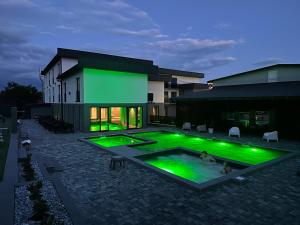 a building with a swimming pool with green lights at Gravity Resort & Spa in Solotvyno