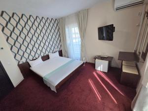 a bedroom with a large bed and a television at Casa Izabela in Năvodari +34 photos