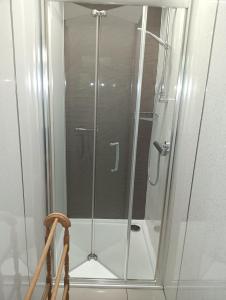 a shower with a glass door in a bathroom at Lucker mill shepherds huts in Lucker +21 photos