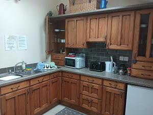 a kitchen with wooden cabinets and a microwave at Lucker mill shepherds huts in Lucker
