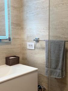 a bathroom with a sink and a glass shower door at Taca 2 - Airport apartman in Surčin +18 photos