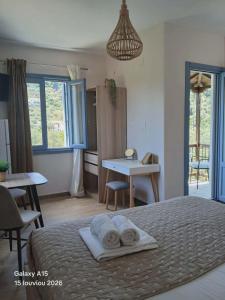 a bedroom with a bed with towels on it at Dafnes in Skopelos Town