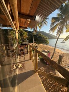 a view of the beach from the porch of a beach house at Suítes Recanto dos papagaios in Angra dos Reis