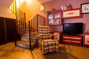 sala de estar con silla y TV en El Leñador I, en Hoyos del Espino