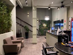 a lobby with chairs and a bar in a store at Primum Palace Hotel in Dracena