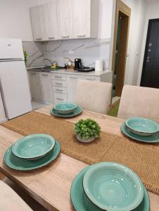 a table with four green plates on it in a kitchen at Apartman Vida in Novi Pazar