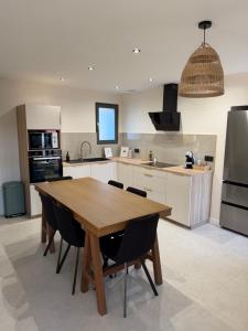 a kitchen with a wooden table and chairs at Maison S&L in Le Pontet