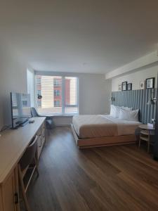 a bedroom with a bed and a desk with a television at Marina Square Suites in Bremerton +84 photos