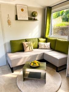 a living room with a green couch and a table at Tolles Mobilheime in super Strandnähe in Saint-Raphaël
