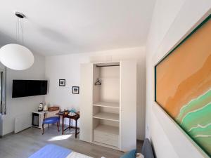 a room with a bed and a desk and a tv at B&B Edda Maison Centralissimo sul Lungomare con Posto Auto e Giardino Privato in Sperlonga