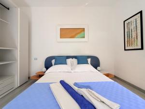 a bedroom with a large bed with blue sheets at B&B Edda Maison Centralissimo sul Lungomare con Posto Auto e Giardino Privato in Sperlonga