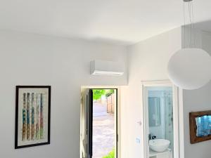 a white bathroom with a sink and a mirror at B&B Edda Maison Centralissimo sul Lungomare con Posto Auto e Giardino Privato in Sperlonga