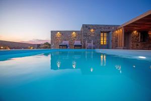 a villa with a swimming pool at night at South Star private Mini Villa in Mikonos