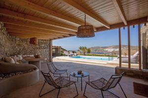 a patio with a couch and chairs and a pool at South Star private Mini Villa in Mikonos +22 photos
