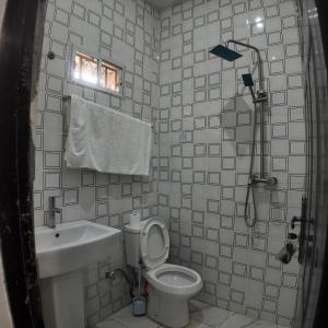 a bathroom with a toilet and a sink and a shower at Shana Homes in Karsana +6 photos