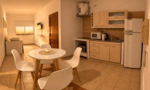 a kitchen with a table and chairs and a kitchen with a refrigerator at Destino Wilde in Resistencia