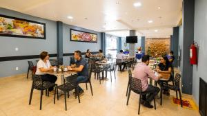a group of people sitting at tables in a restaurant at Barrudada Palace Hotel-Boa Vista in Boa Vista